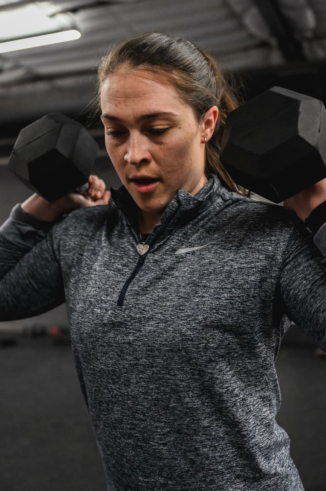 member focused on dumbbell strength training at District H in Houston Heights