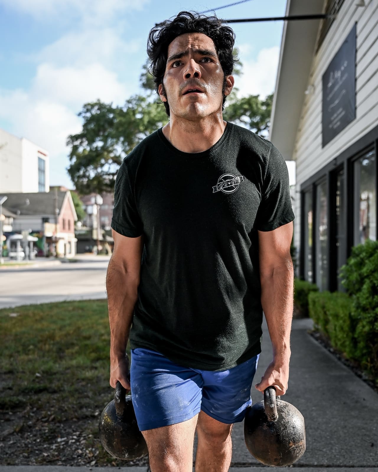 District H member carrying kettlebells on Studewood Street in Houston Heights