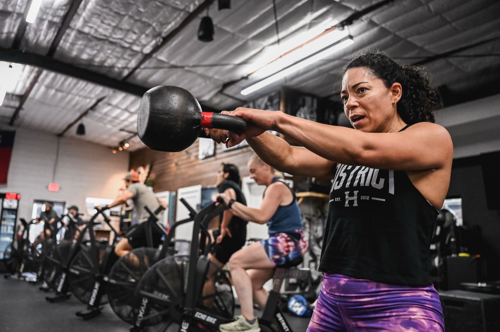 member doing kettlebell swings in a group session at District H in the Houston Heights